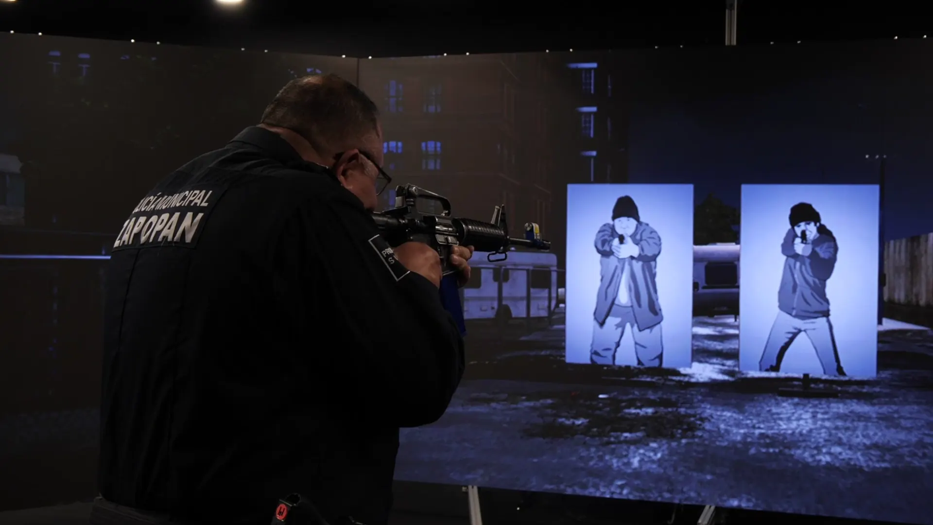 Zapopan Municipal Police officer practicing on a virtual shooting simulator in front of a nighttime urban scenario